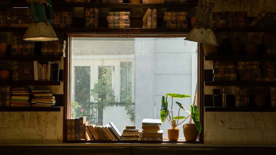 本や植物、温かい光が差し込む、レトロな窓辺の景色。