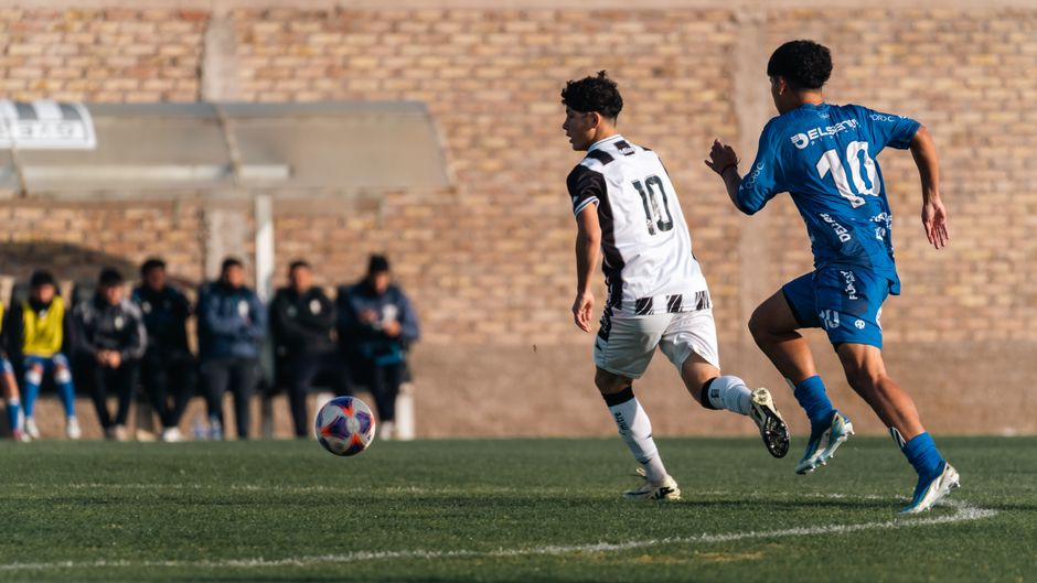 2人のサッカー選手がフィールド上で激しく競い合い、スポーツマンシップと敏捷性を見せつけている。