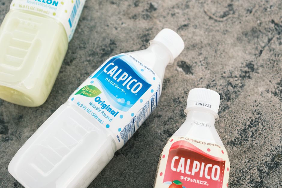 テクスチャ加工されたコンクリートの表面に置かれたカルピコ飲料ボトルのクローズアップ。