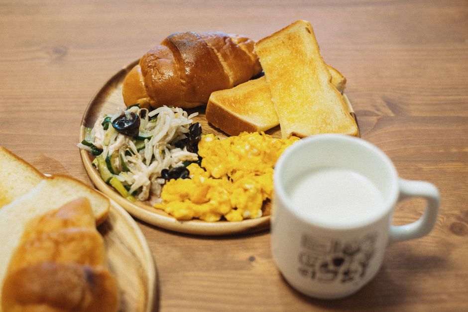 スクランブルエッグ、パン、サラダ、牛乳が付いた美味しい和朝食。東京都板橋区で撮影。