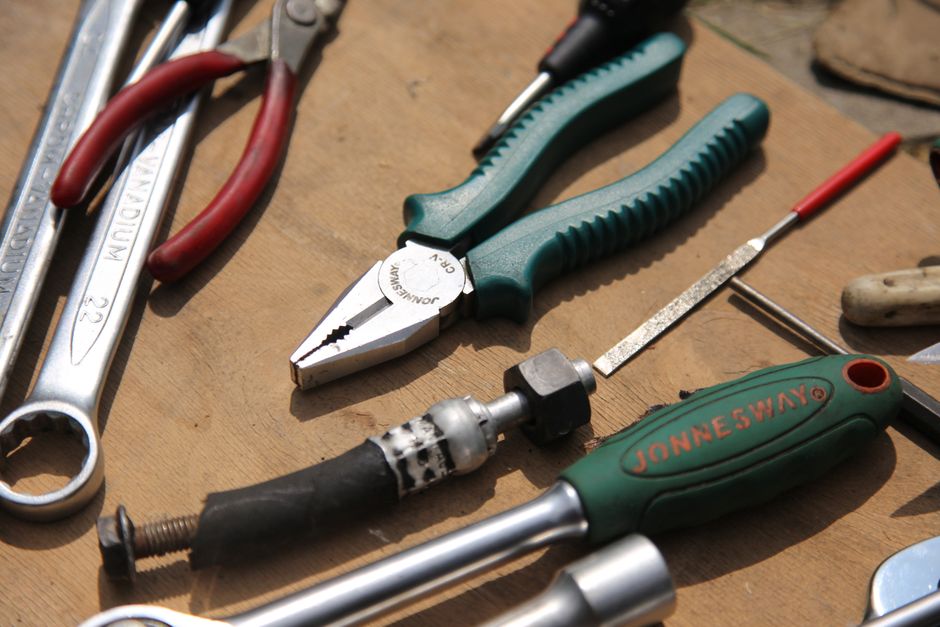 DIY プロジェクトに最適な、木製の表面に置かれたさまざまな手工具のクローズアップ。